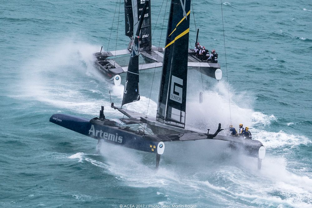 Artemis Racing and Softbank Team Japan just about bear away at the top mark in winds that are hitting the upper limit allowed for racing on day 3 of the playoff semi-finals. Correct hydrofoil choice and precise control seem to be key in the big winds. Photo: ACEA 2017/Gilles Martin-Raget.
