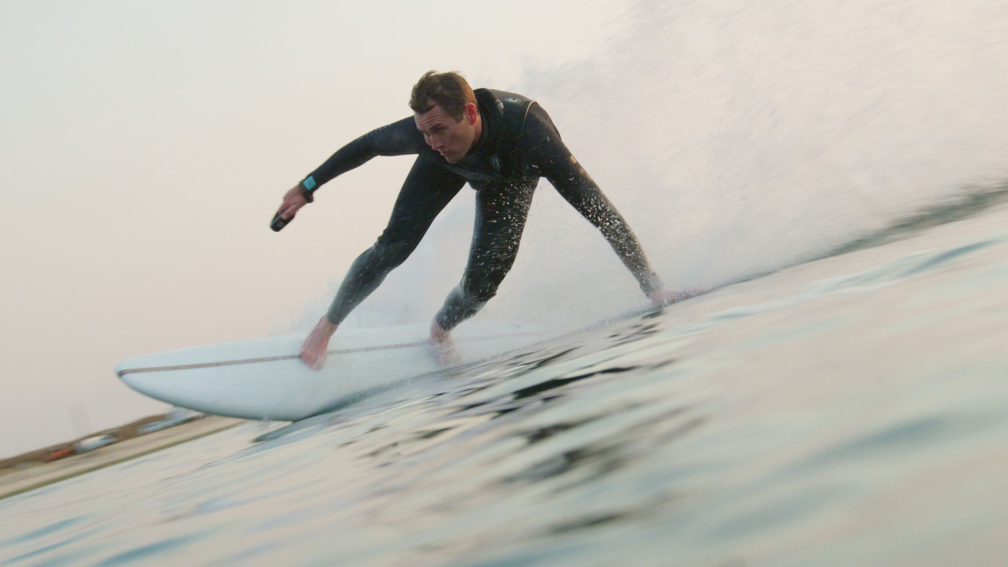 A man surfing on a LIND Canvas electric surfboard