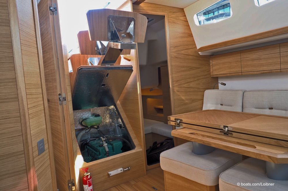 Zugang zum motor hinter der hochgeklappten Niedergangstreppe. Davor, rechts der absenkbare Salontisch mit den entfernbaren Hockern. Foto: boats.com/Loibner
