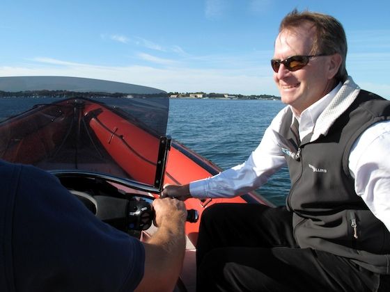 john-burnham-aboard-protector-jet-17072 The author enjoys a smooth ride on one of the Protector Jet's five, chambered Hypalon tubes. At 40 mph, his hair is slightly out of place and his boat show name tag is flapping in the breeze.