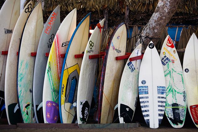 many surfboards lined up near beach hut