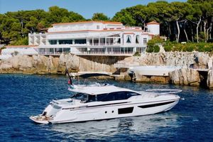 Azimut S8 2023 Azimut S8 yacht cruising near a luxurious coastal villa.