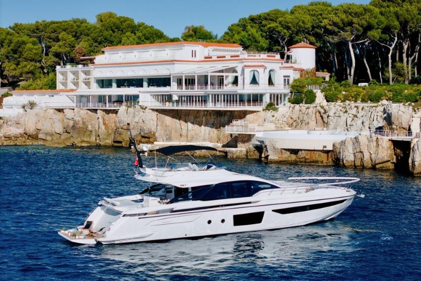 Azimut S8 2023 Azimut S8 yacht cruising near a luxurious coastal villa.