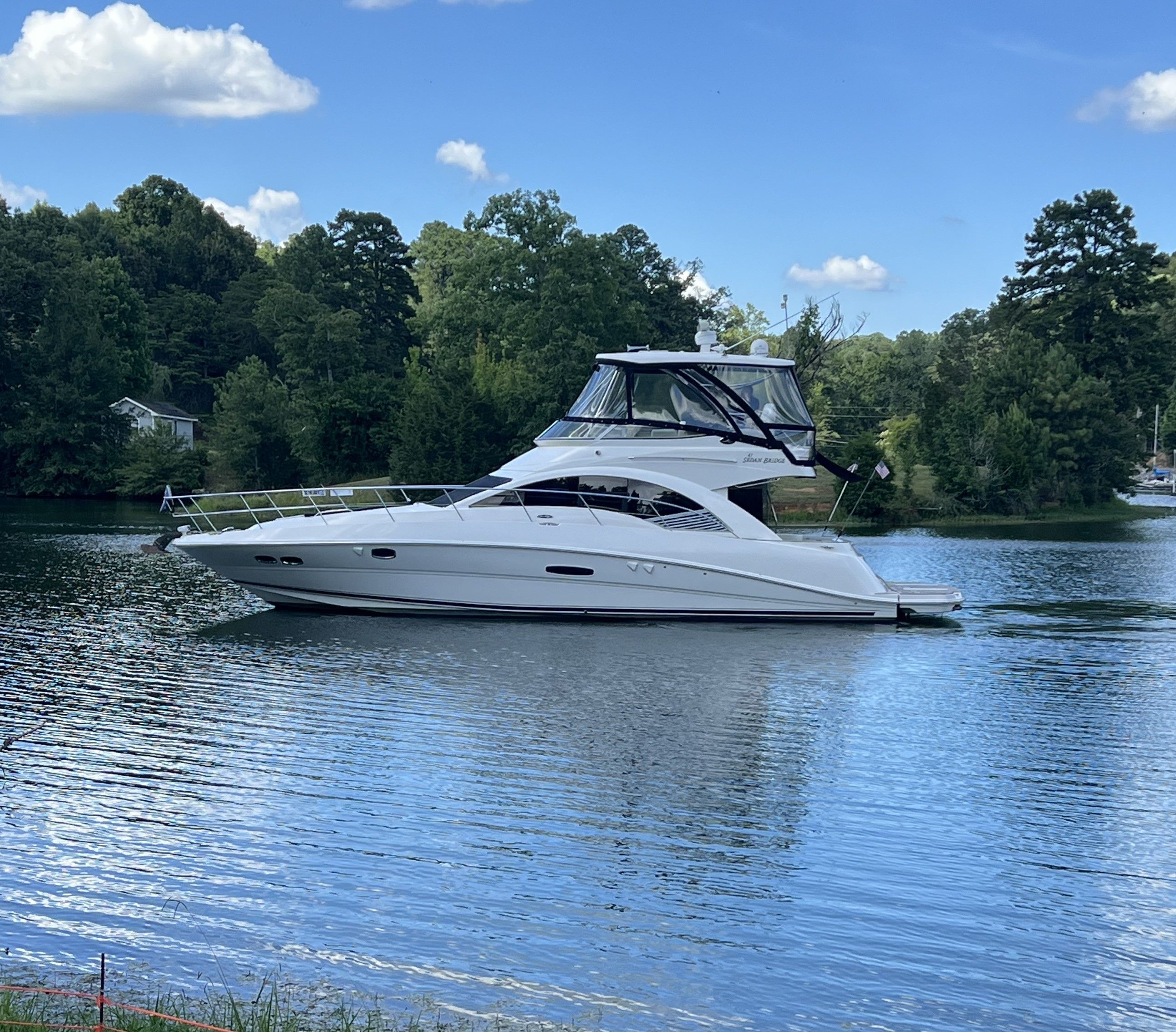 Sea Ray 47DB 2008 Sea Ray 47DB yacht on a serene lake with lush green trees.