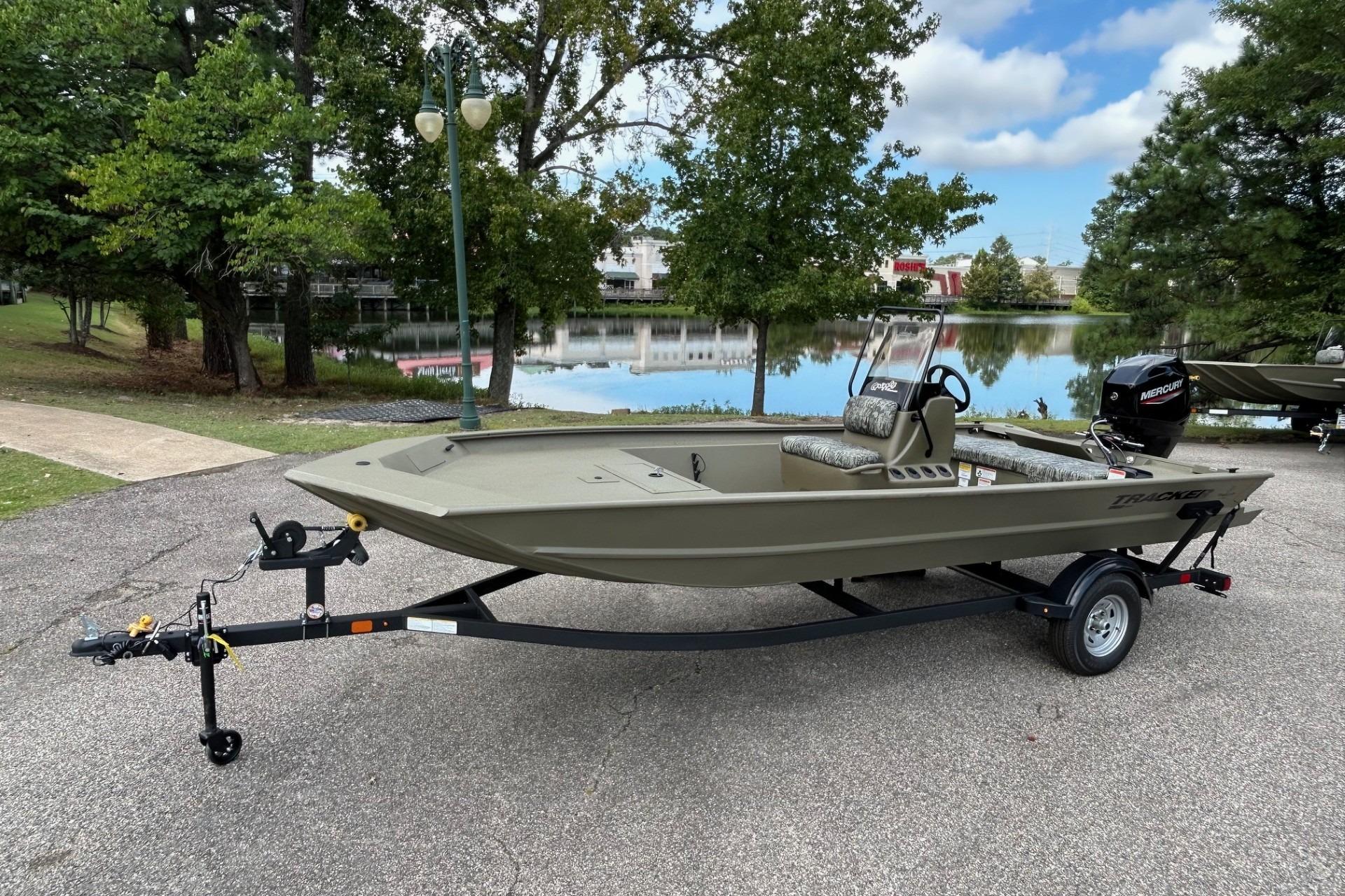 Tracker Grizzly 1860 CC 2026 Tracker Grizzly 1860 CC boat on trailer by a scenic lake.