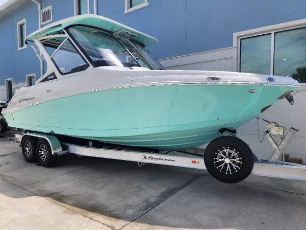 Finseeker 280 DC 2024 Finseeker 280 DC boat on trailer, mint green hull, docked outside.