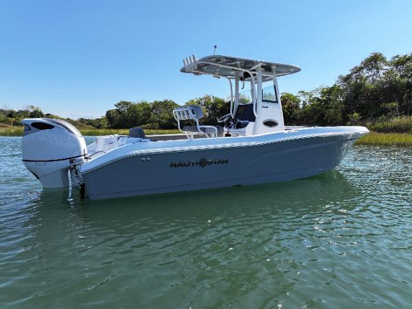 NauticStar 242OS 2025 NauticStar 242OS boat on calm water, side view.