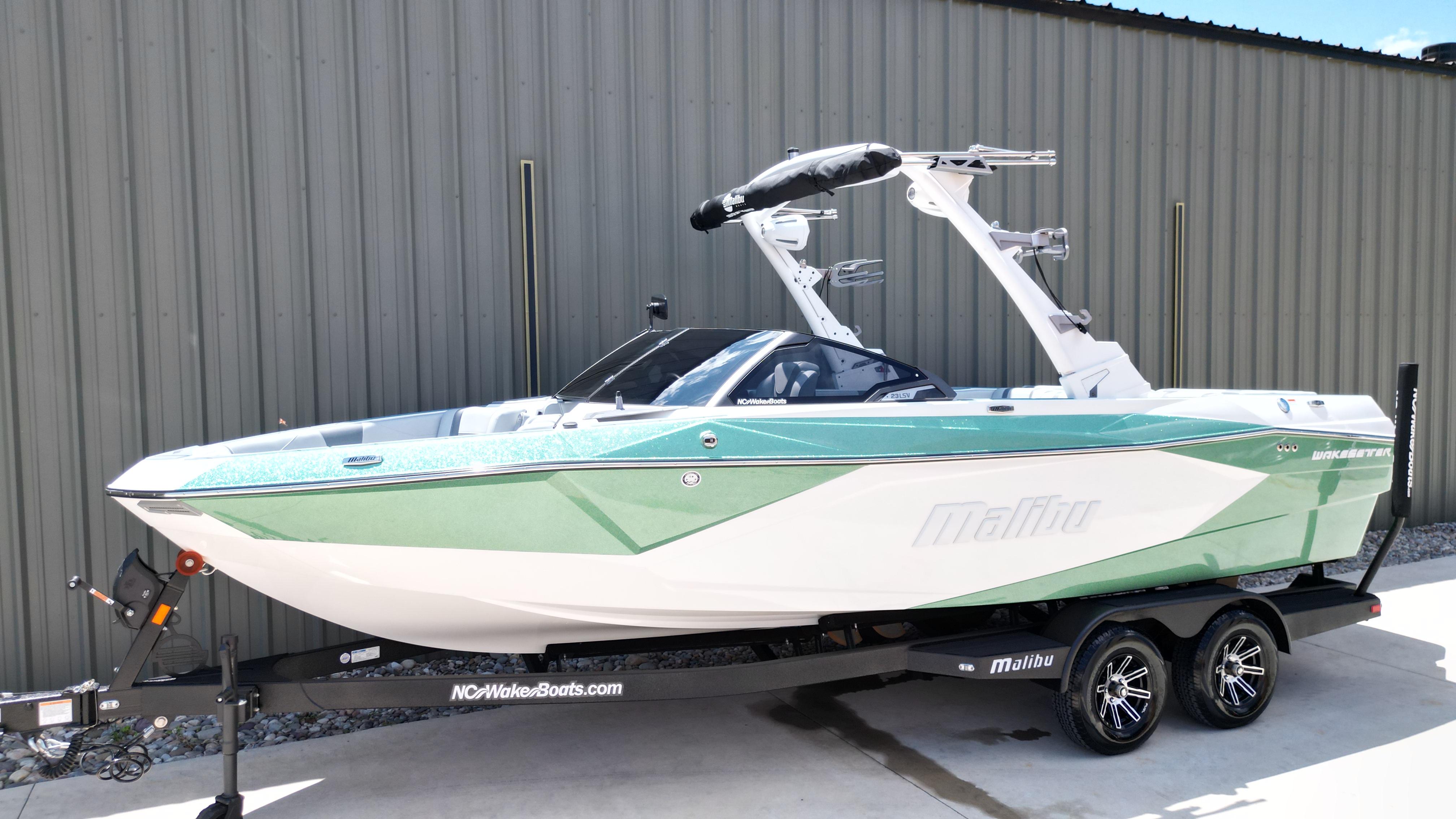 Malibu Wakesetter 23 LSV 2025 Malibu Wakesetter 23 LSV boat on trailer, green and white design, parked outdoors.