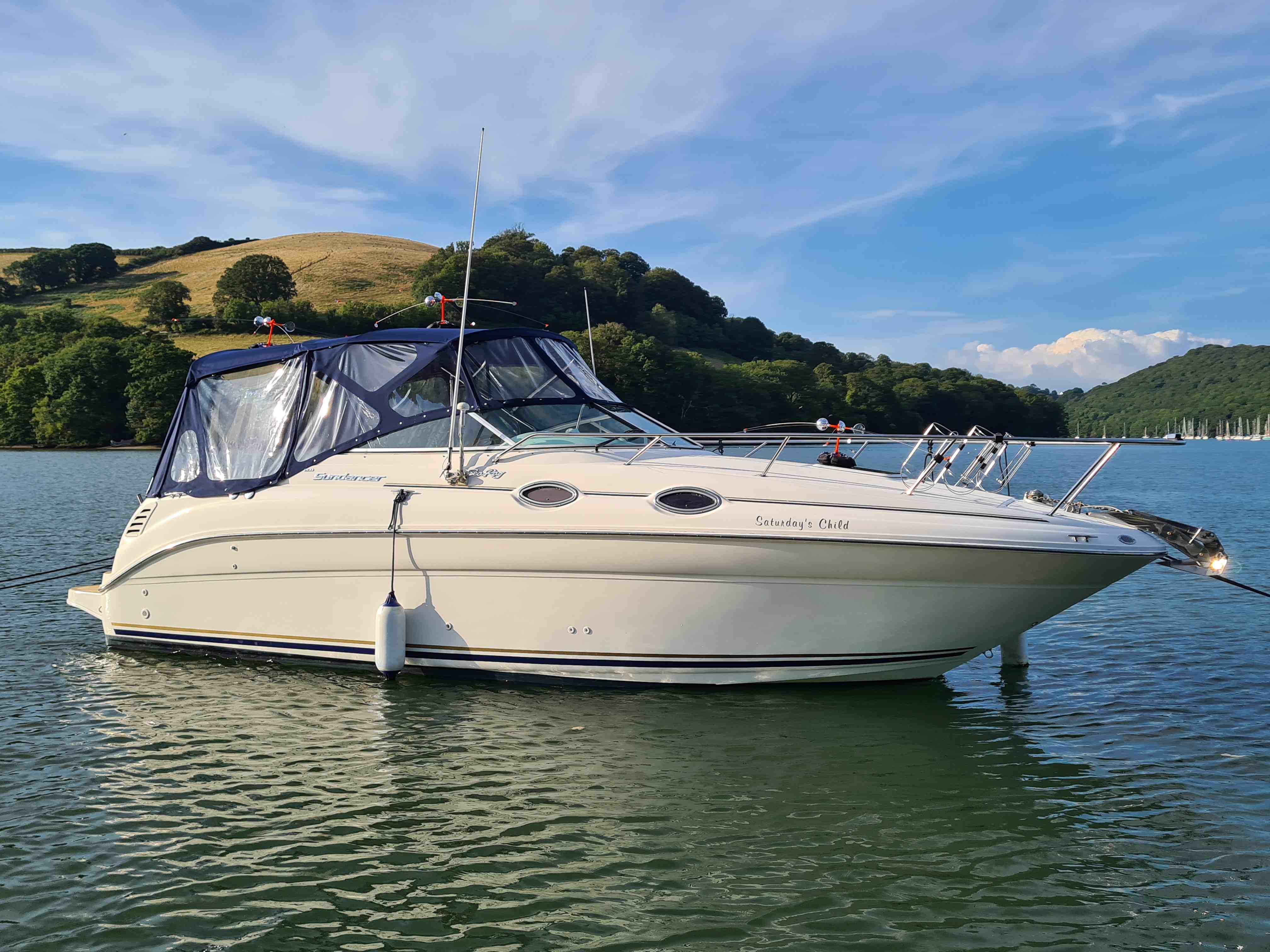 Sea Ray 260 Sundancer 2000 Sea Ray 260 Sundancer boat on calm water with scenic hillside background.