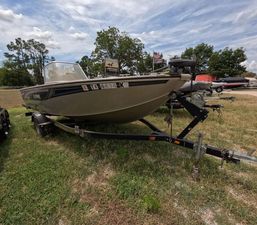 Lowe Fish & Ski 175 2005 Lowe Fish & Ski FS175 boat on trailer, parked on grass under cloudy sky.