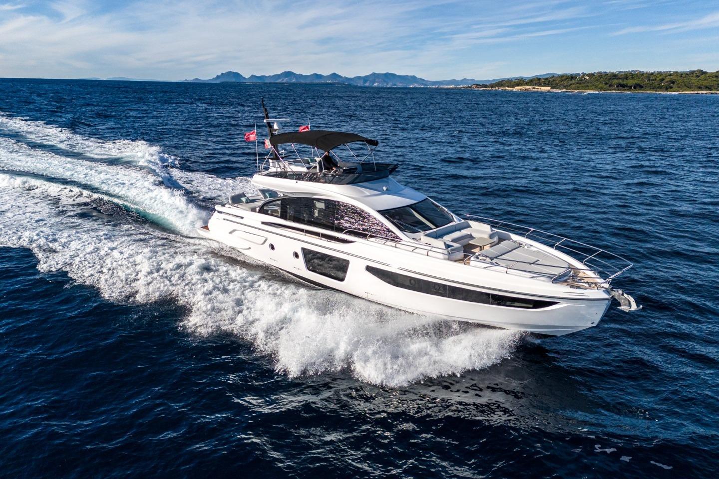 Azimut S7 2023 Azimut S7 yacht cruising on open sea with scenic coastline backdrop.