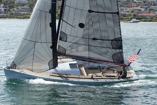 Maxi Dolphin Cross Current 33 Sailing yacht Maxi Dolphin Cross Current 33, 2006, gliding on water with American flag.