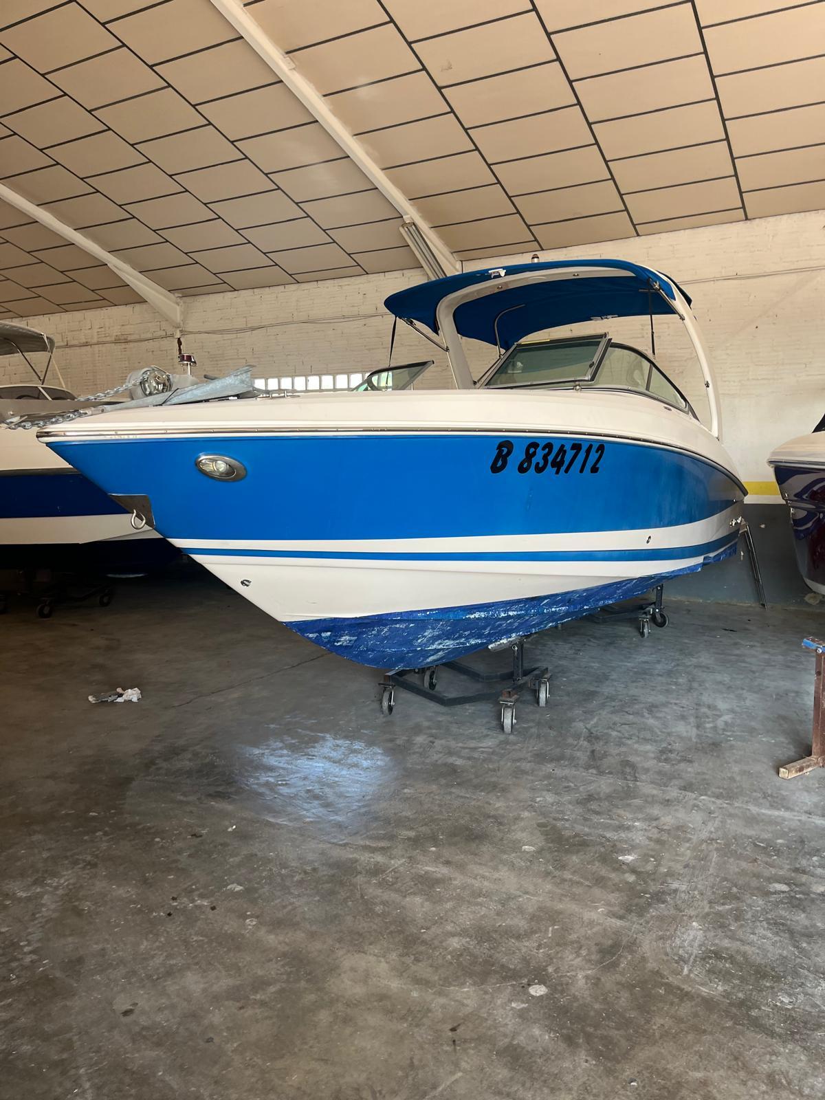 Regal 2500 2009 Regal 2500 boat in storage, blue and white exterior, indoors.