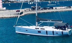 Hanse 455 2017 Hanse 455 sailboat docked in a marina with a scenic ocean backdrop.