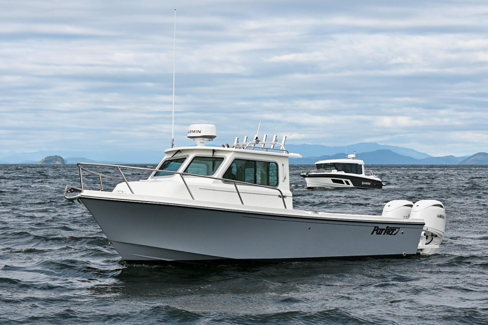 Parker 2420 Sport Cabin 2025 Parker 2420 Sport Cabin boat on open water, with distant mountains and cloudy sky.