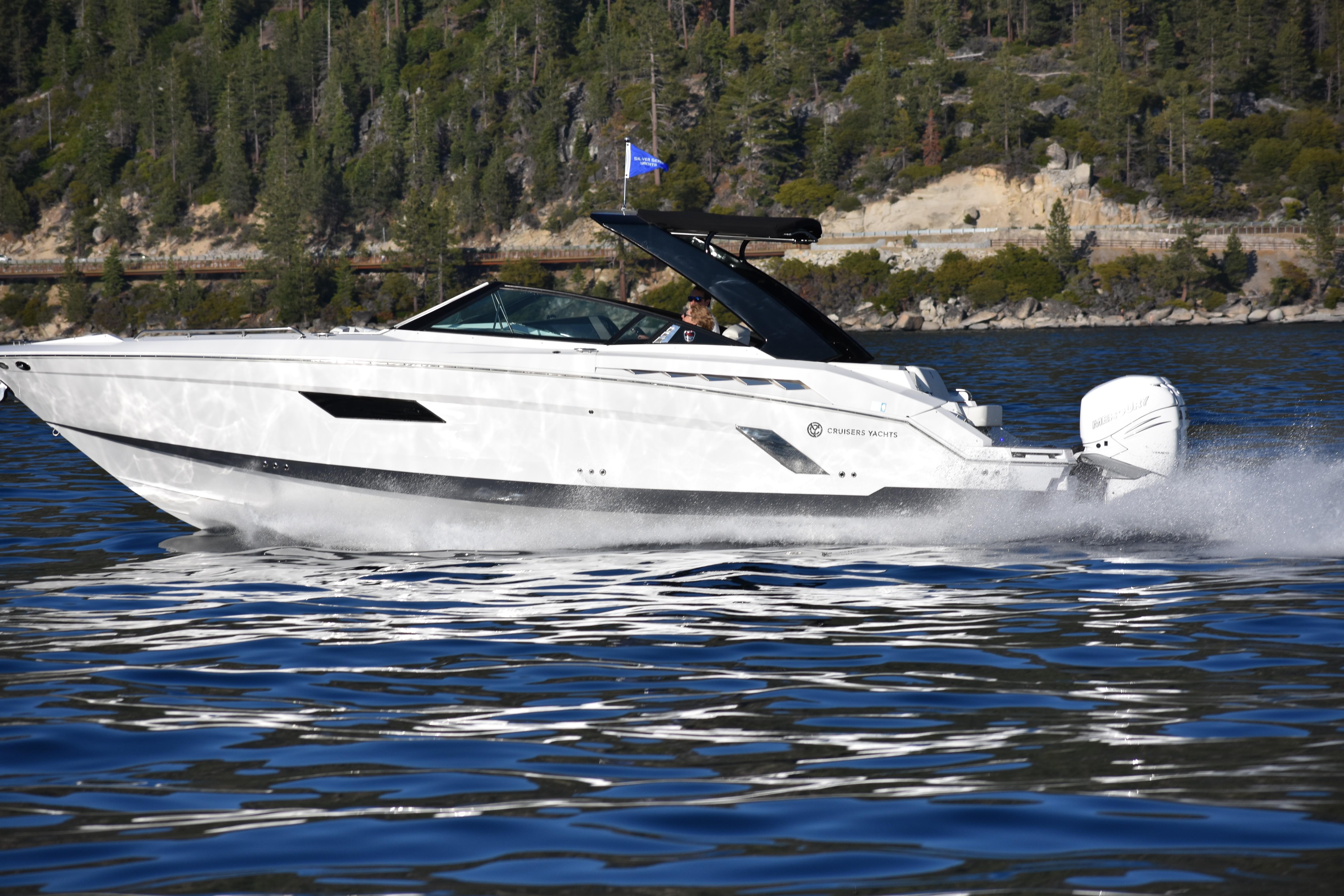 Cruisers Yachts 338OB 2020 Cruisers Yachts 338OB speeding on a scenic lake with forested hills.