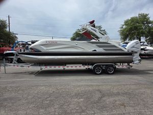 Bennington QX 25 Sport 2020 Bennington QX 25 Sport pontoon boat on a trailer, parked outdoors.