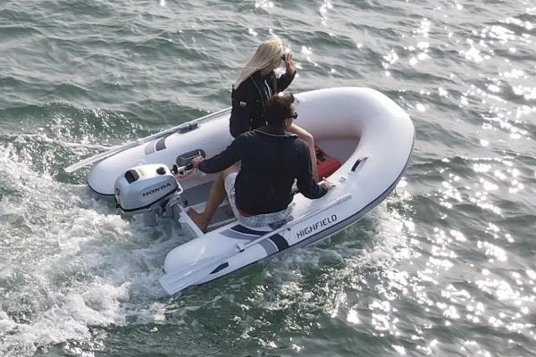 Highfield Ultralite 240SS 2025 Highfield Ultralite 240SS inflatable boat on water with two passengers.