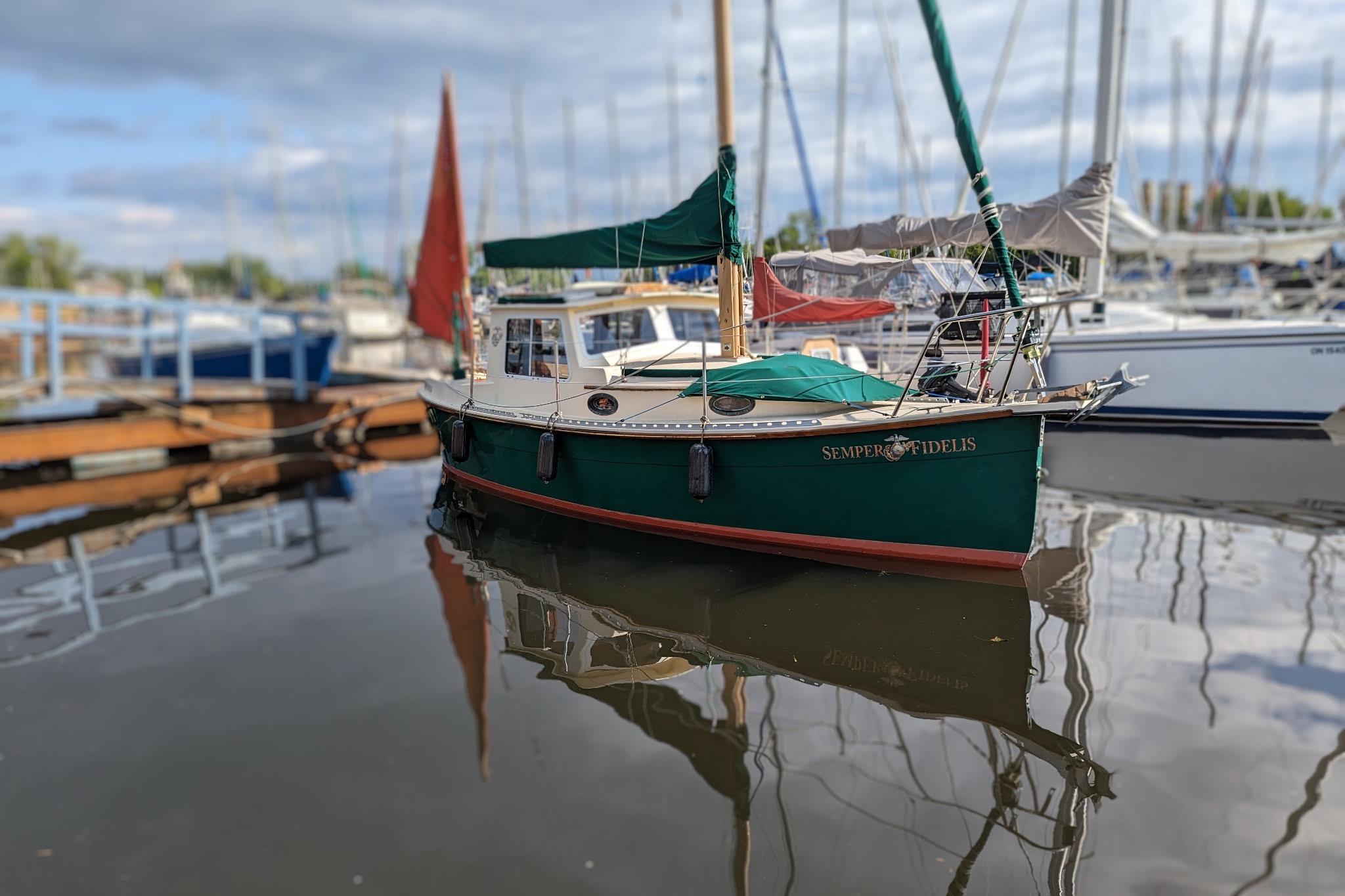 Nimble 25 Arctic Pilothouse 1992 Nimble 25 Arctic Pilothouse boat docked in a marina, reflecting on calm water.