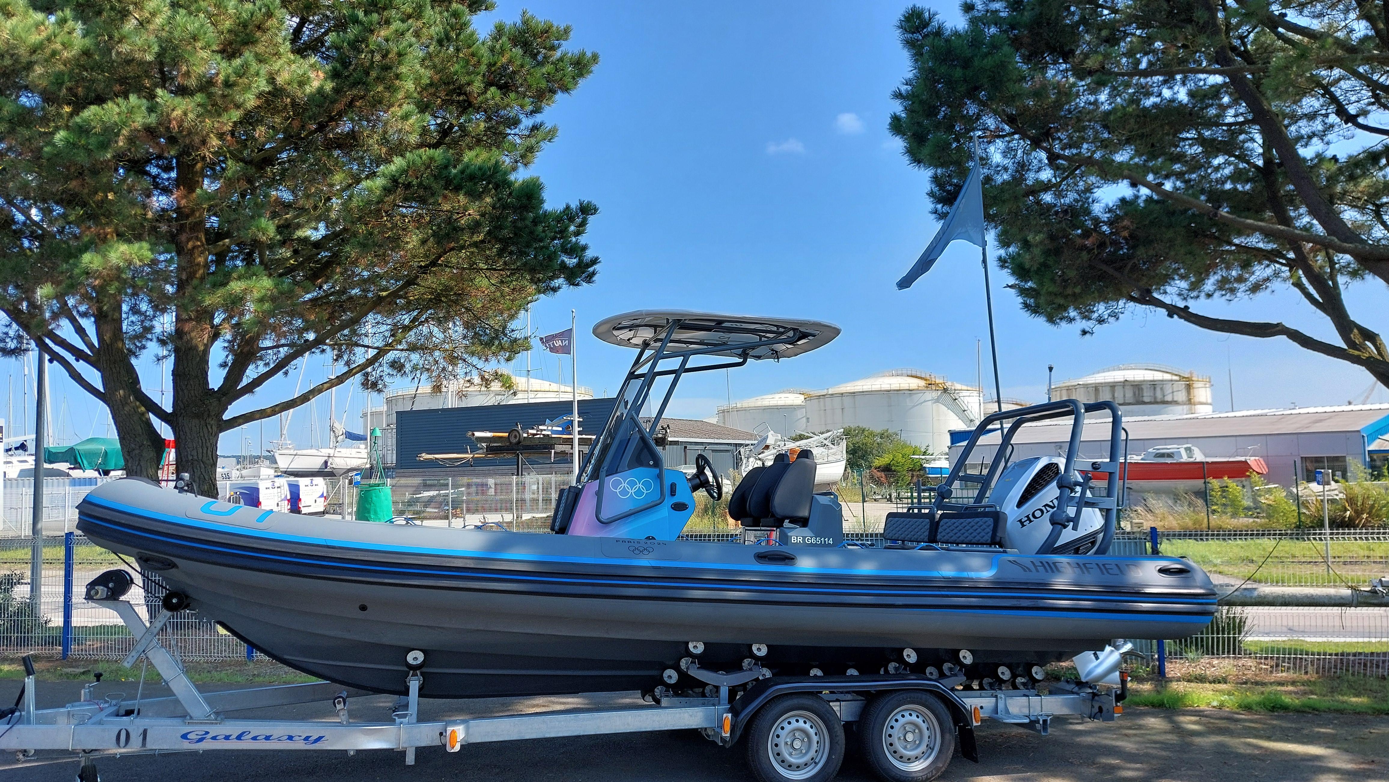 Highfield Sport 700 JO 2024 2024 Highfield Sport 700 JO boat on trailer, parked near trees and industrial buildings.