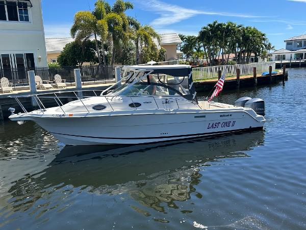 Wellcraft 290 Coastal 2015 Wellcraft 290 Coastal boat docked in sunny marina with palm trees.