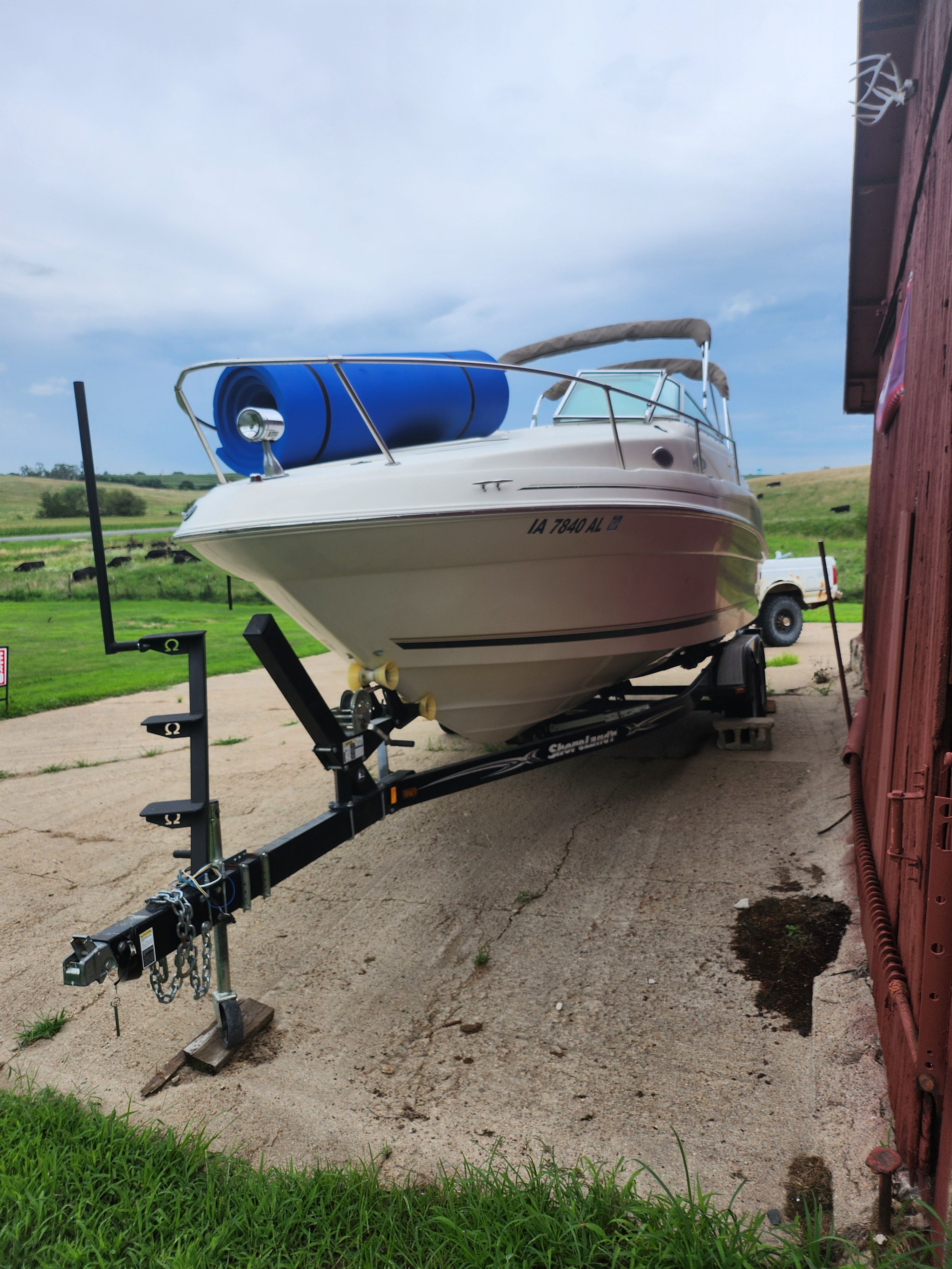 Sea Ray 240 Sundancer 1999 Sea Ray 240 Sundancer boat on trailer, parked outdoors near a red building.