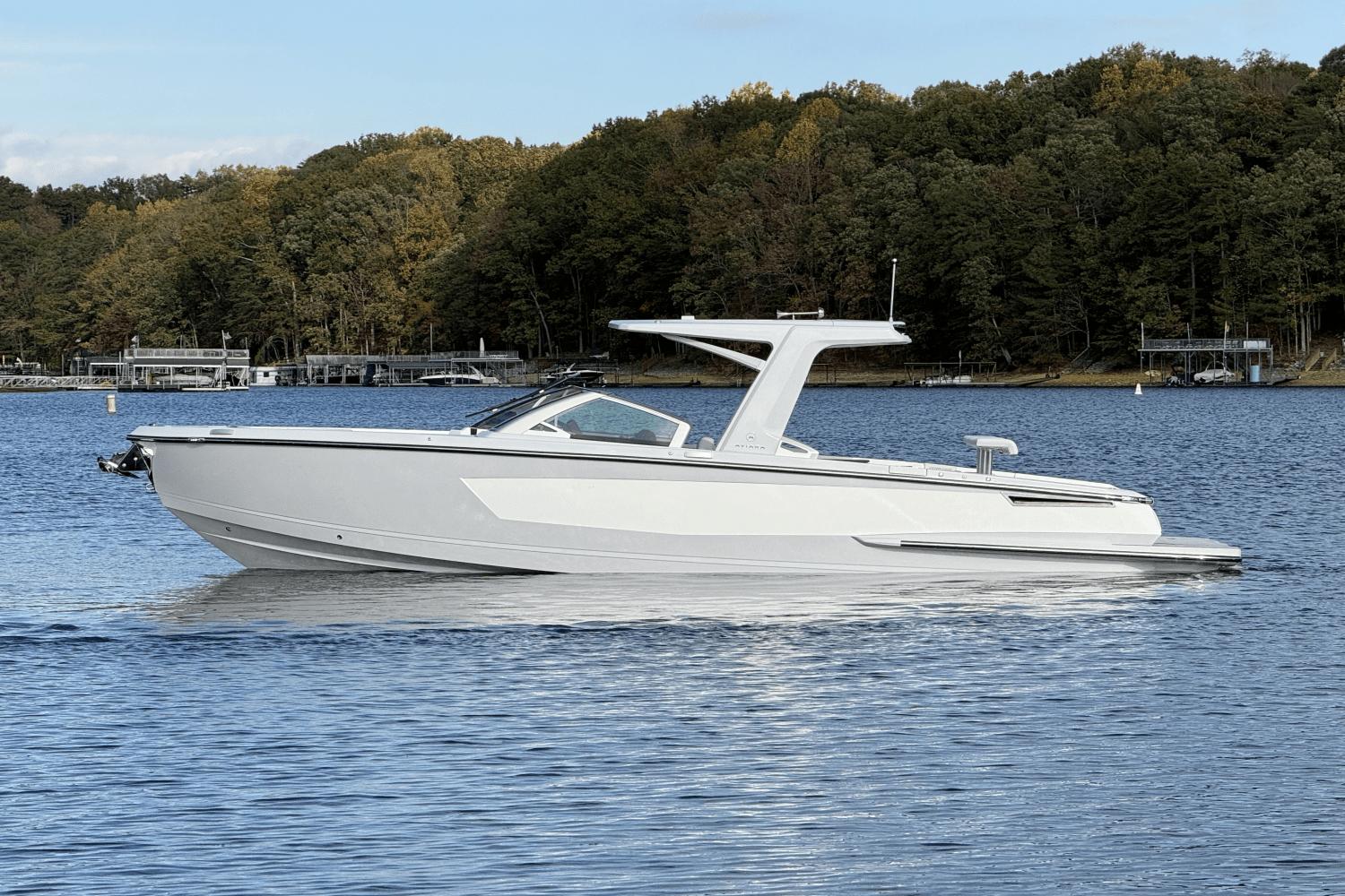 Aviara AV32 2024 Aviara AV32 boat on a serene lake with forested shoreline.