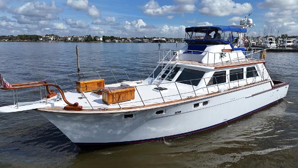 Bertram 1980/2010 58 Convertible Complete Rebuild in 2010 from Hull Up 1980 Bertram 58 Convertible Custom yacht on calm water under a cloudy sky.