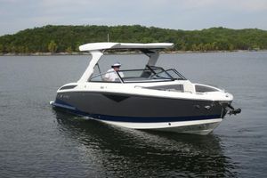 Cobalt A29 2026 Cobalt A29 boat cruising on a calm lake with lush green shoreline.
