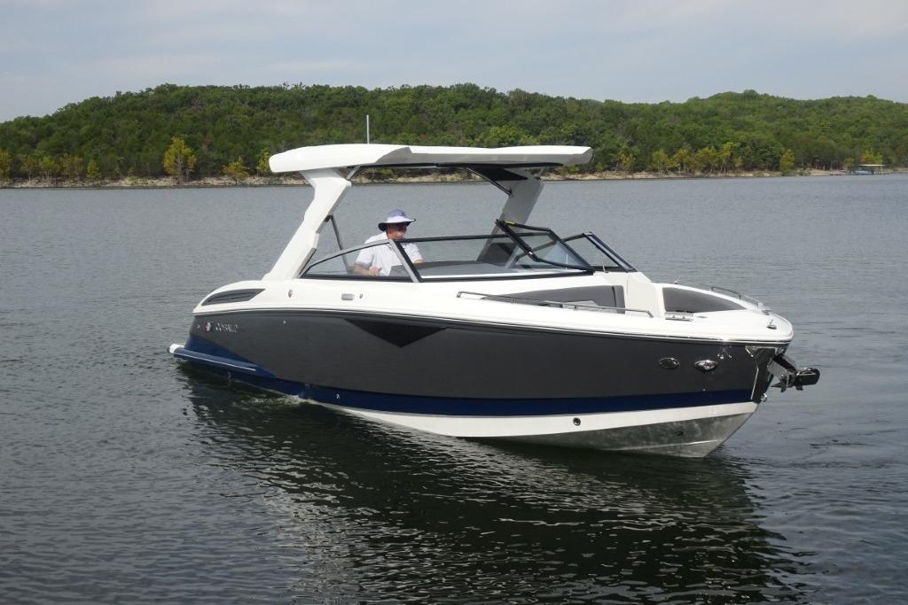 Cobalt A29 2026 Cobalt A29 boat cruising on a calm lake with lush green shoreline.