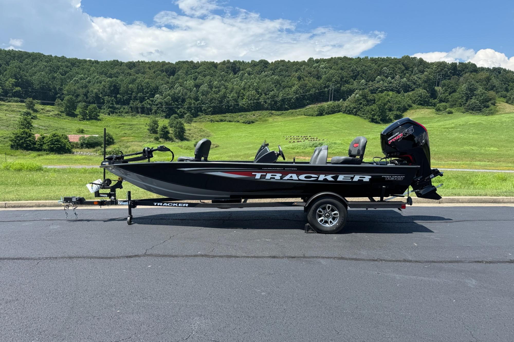 Tracker Pro Team 190 2026 Tracker Pro Team 190 boat on trailer, parked with scenic green hills in background.