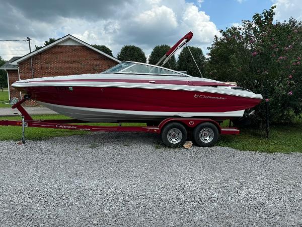 Crownline 225 SS 2017 Crownline 225 SS boat on trailer, red and white, parked on gravel.