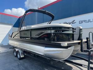 Barletta Corsa 23U 2025 Barletta Corsa 23U pontoon boat on trailer, parked outside a building.