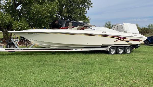 Fountain 38 Fever 1998 Fountain 38 Fever speedboat on trailer, parked on grass, side view.