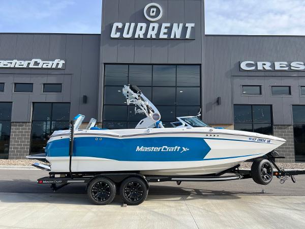 MasterCraft Xstar 2018 MasterCraft XStar boat in blue and white, parked outside dealership.