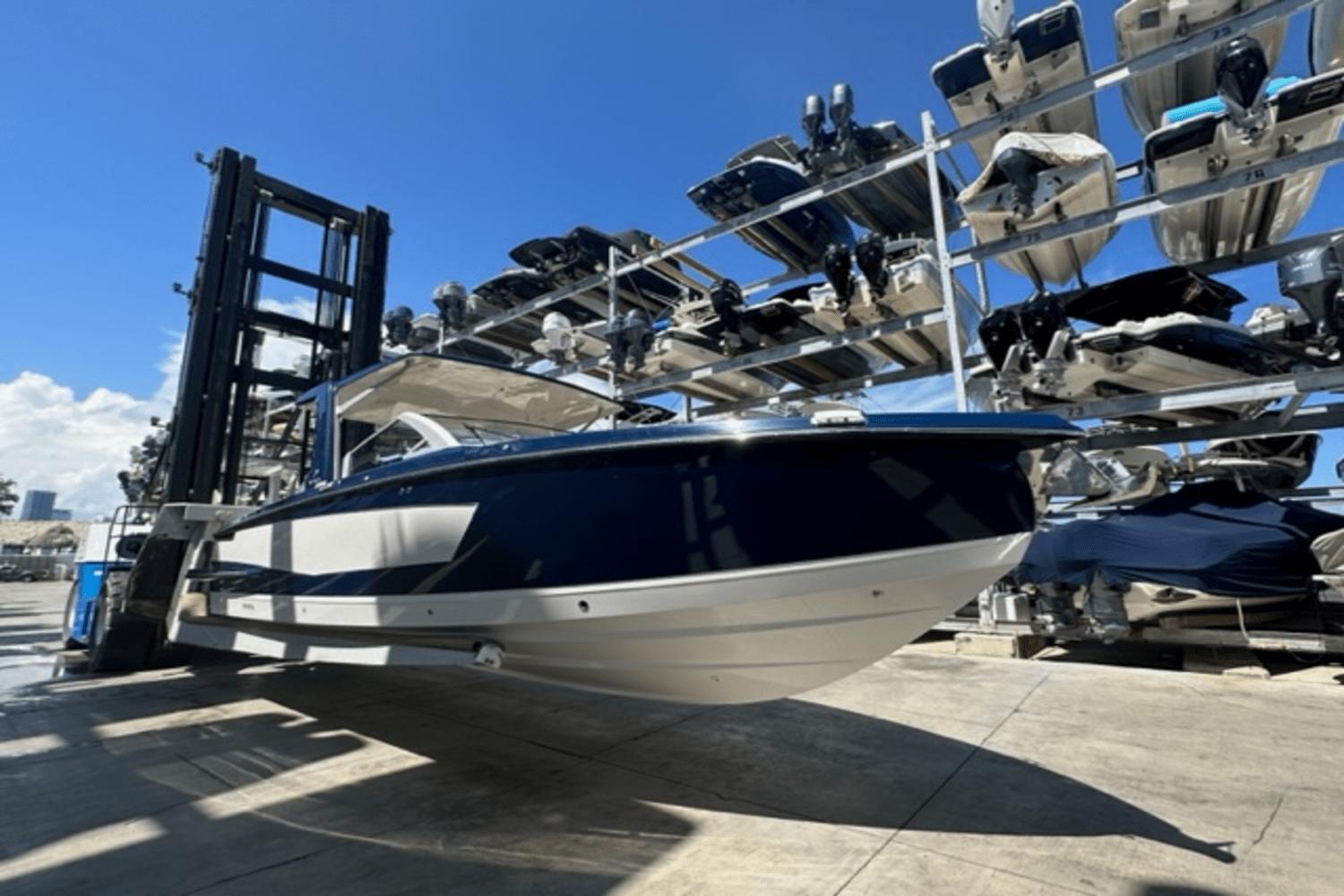 Aviara AV32 Outboard 2022 Aviara AV32 Outboard boat in storage, surrounded by other boats under a clear blue sky.