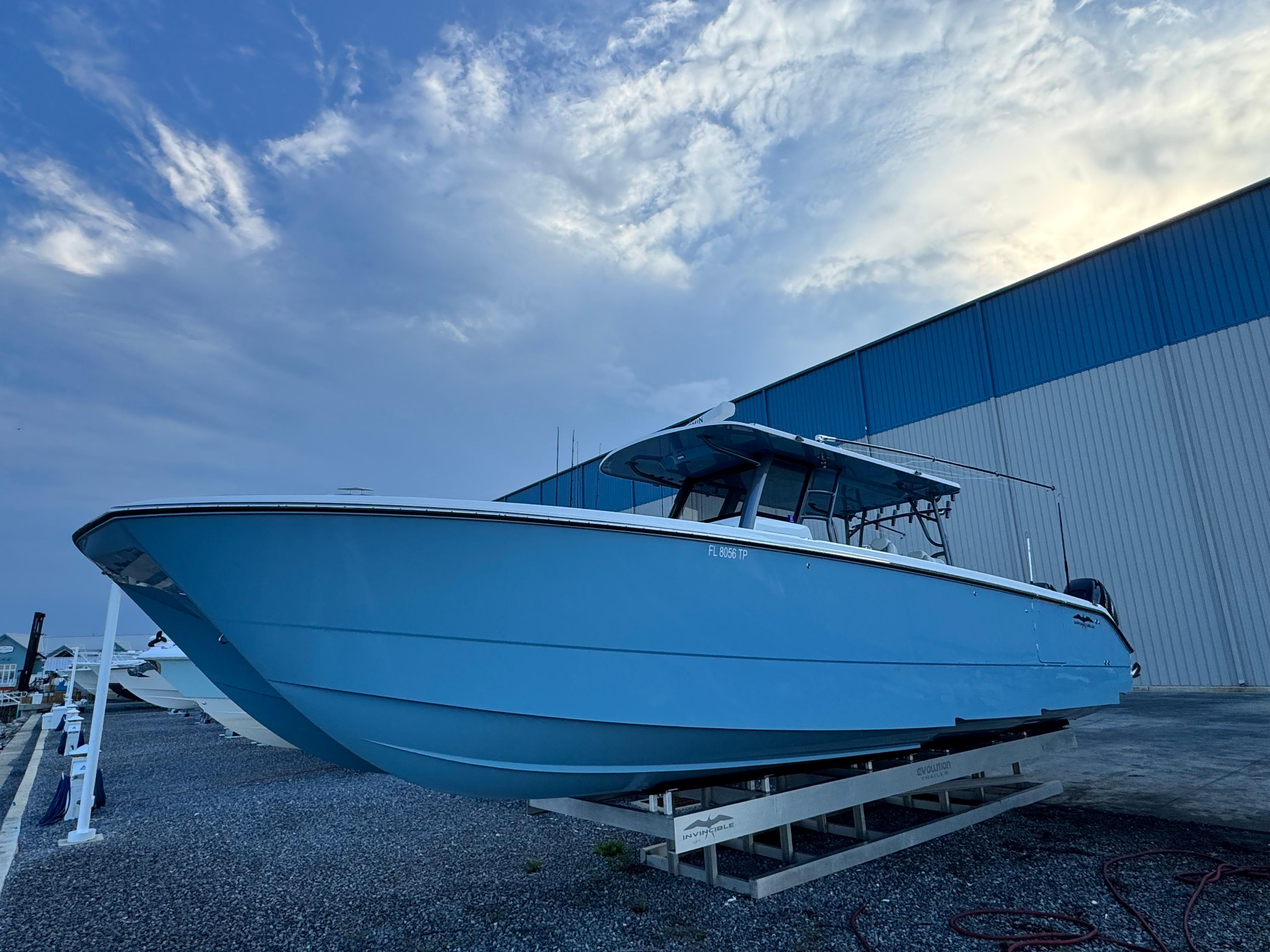 Invincible 40 Catamaran 2022 Invincible 40 Catamaran in blue, docked outdoors under a cloudy sky.