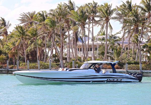 MTI V Marine Technology Inc V 57 2025 MTI V Marine Technology Inc V 57 boat cruising near palm trees and waterfront homes.