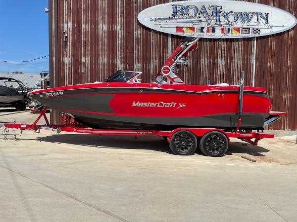 MasterCraft XStar 2021 MasterCraft XStar boat in red and gray on a trailer at Boat Town.