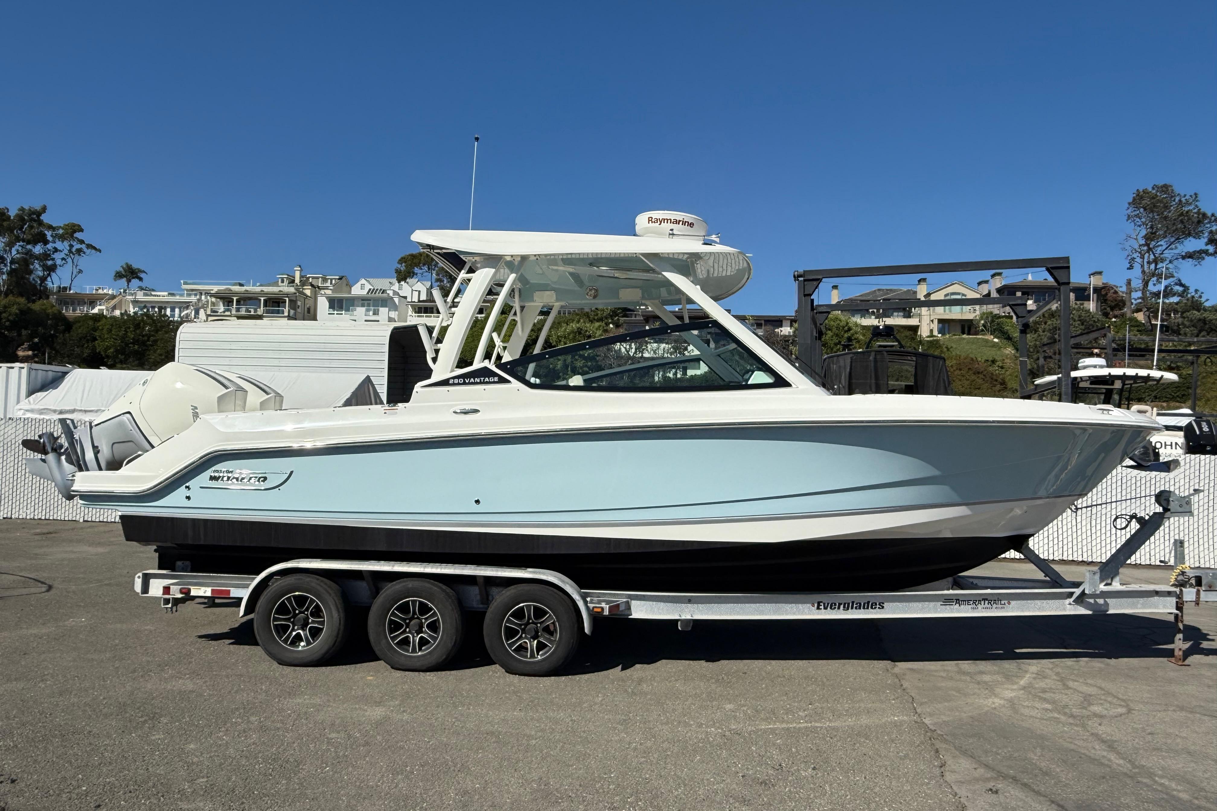 Boston Whaler 280 Vantage 2021 Boston Whaler 280 Vantage boat on trailer, parked outdoors under clear blue sky.