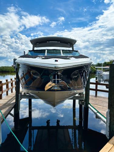 Cobalt 302 2014 Cobalt 302 boat docked on a lift under a bright blue sky.