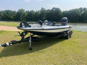 Skeeter ZXR21 2025 Skeeter ZXR 21 boat on trailer by a lake, surrounded by trees.