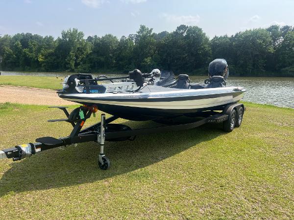Skeeter ZXR 21 2025 Skeeter ZXR 21 boat on trailer by a lake, surrounded by trees.