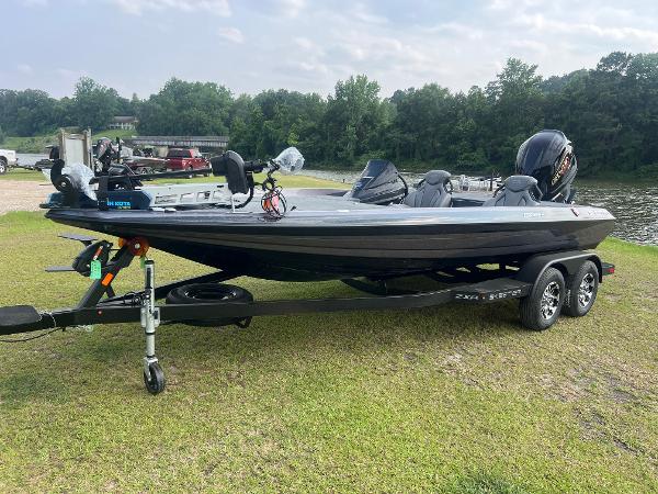 Skeeter ZXR 20 2025 Skeeter ZXR 20 boat on trailer, parked on grass near a lake.
