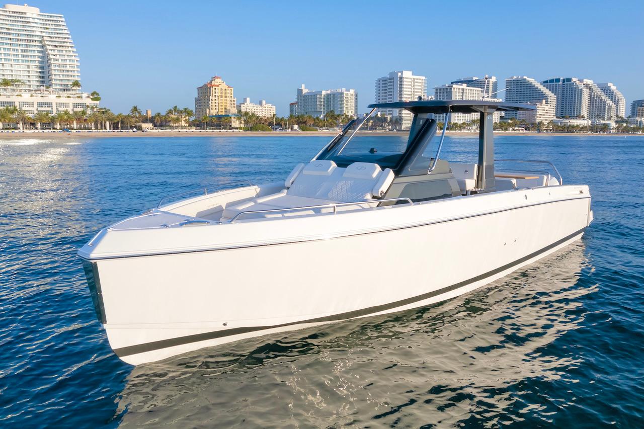 Schaefer V33 2025 Schaefer V33 boat cruising near a coastal city skyline.