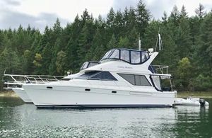 Bayliner 3988 Command Bridge Motoryacht 1998 Bayliner 3988 Command Bridge Motoryacht on calm water, surrounded by lush forest.