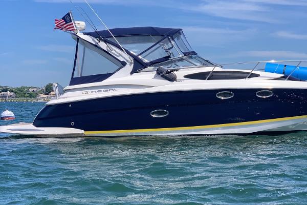 Regal 3360 Window Express 2006 Regal 3360 Window Express boat on water, American flag, clear sky.