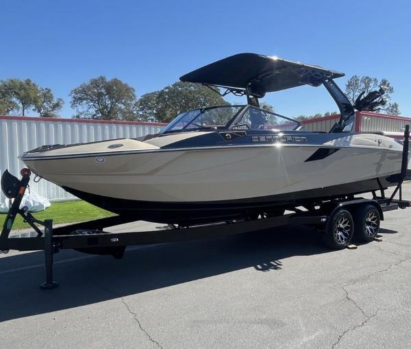 Centurion FE 23 2025 Centurion FE 23 boat on trailer, parked outdoors under clear blue sky.