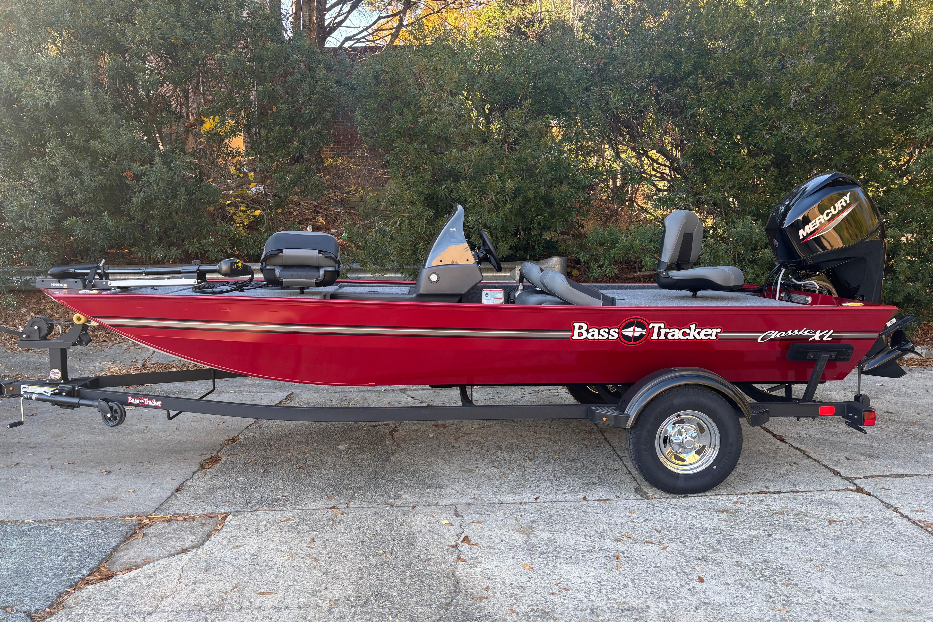 Tracker Bass Tracker Classic XL 2026 Tracker Bass Tracker Classic XL boat, red, on trailer, parked outdoors.