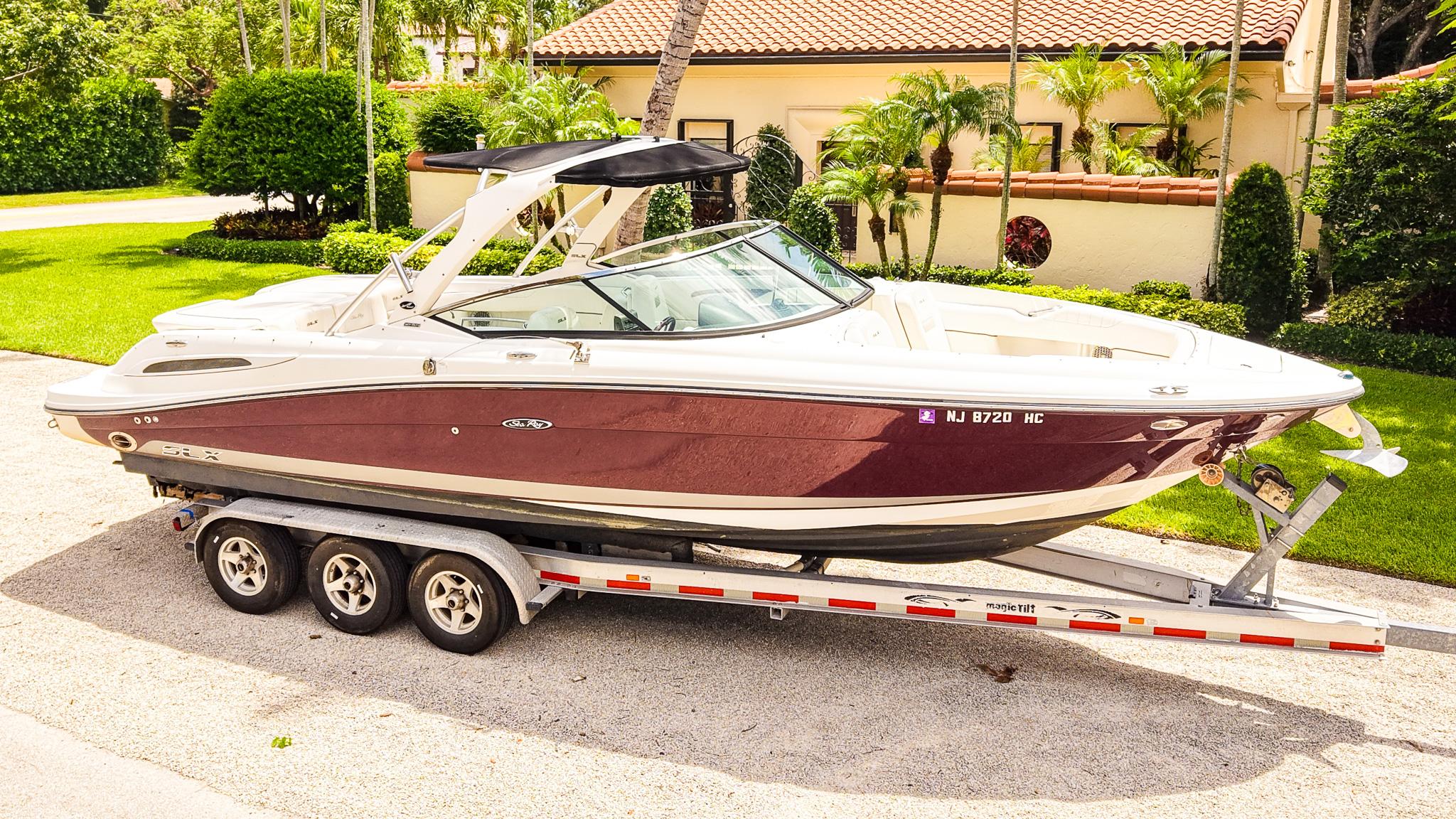 Sea Ray 270 SLX 2010 Sea Ray 270 SLX boat on trailer, parked in a sunny residential area.